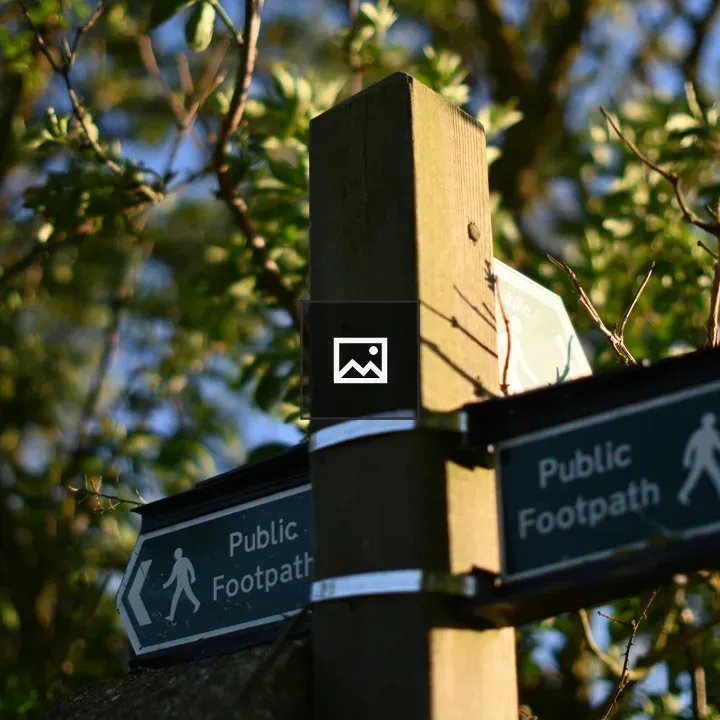 Public footpath sign in hedgerows