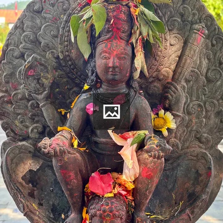 Stone deity statue with petals