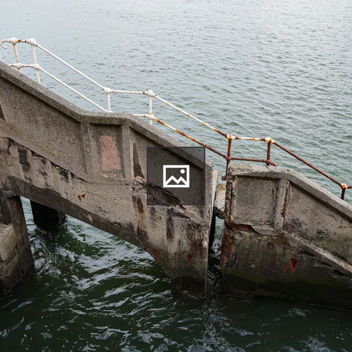 Weathered concrete staircase near water