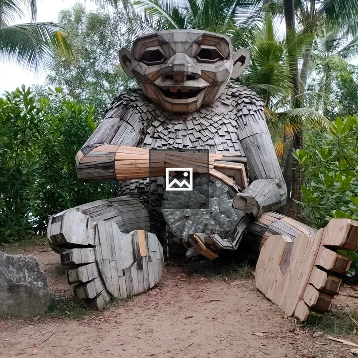 Wooden troll sculpture among tropical plants