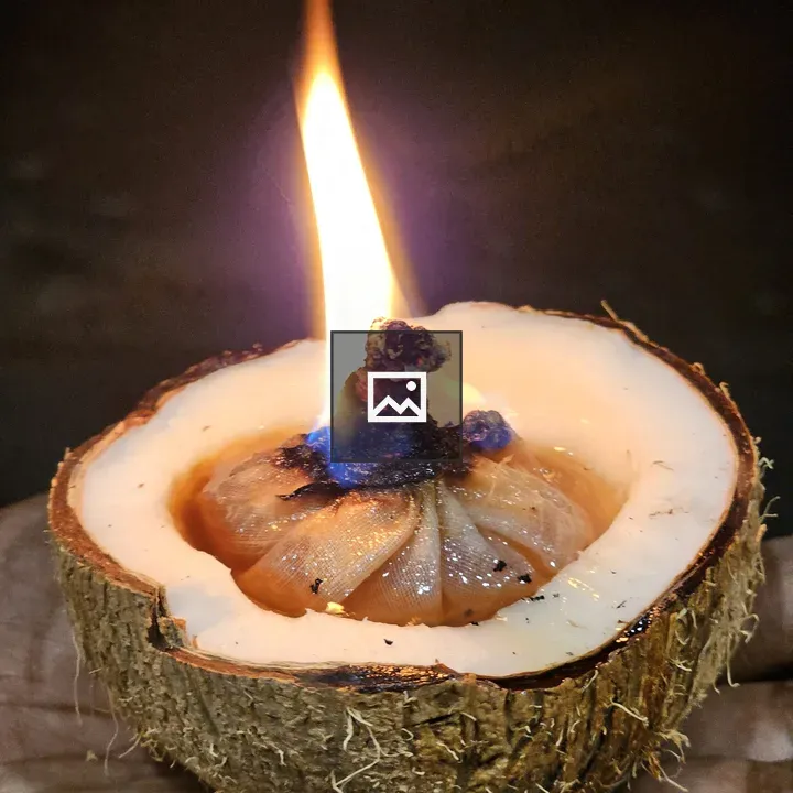 Coconut oil lamp held in hand