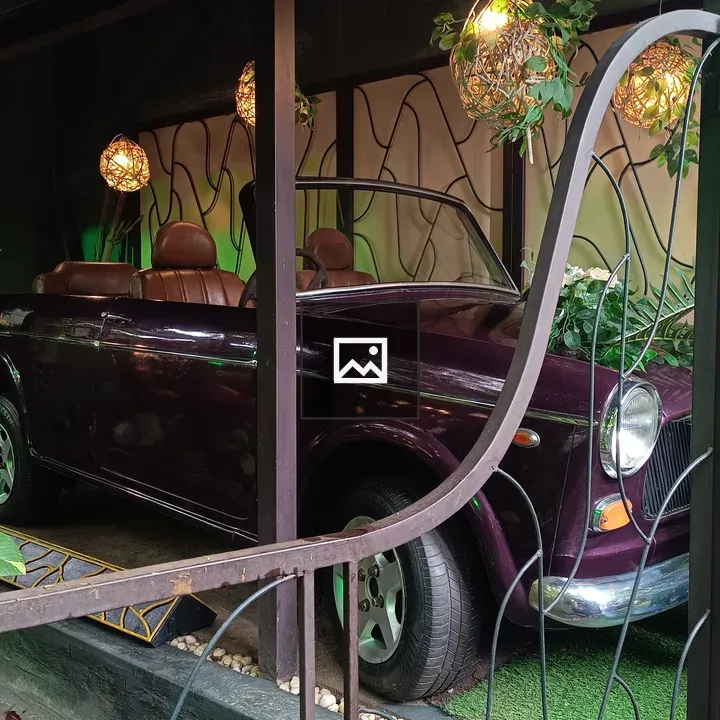 Old purple convertible car behind gate