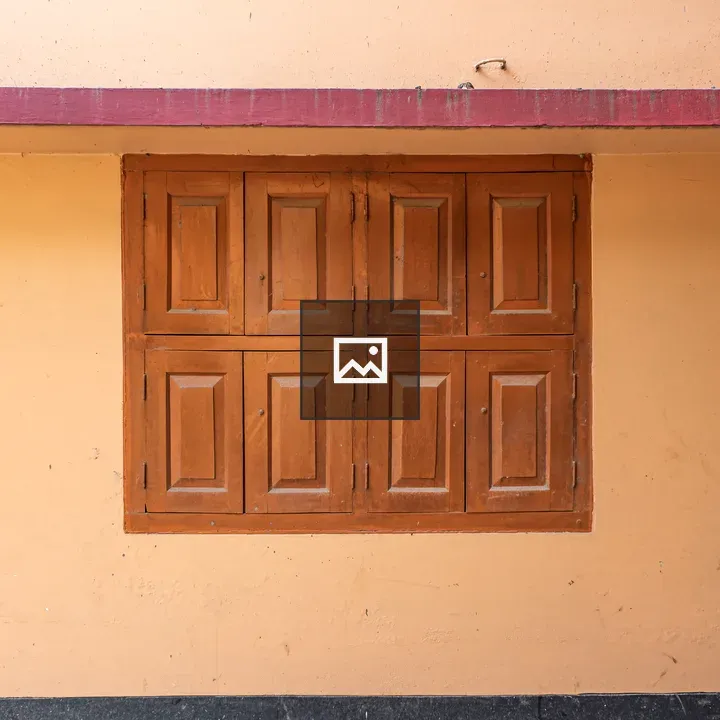Closed wooden windows on peach wall
