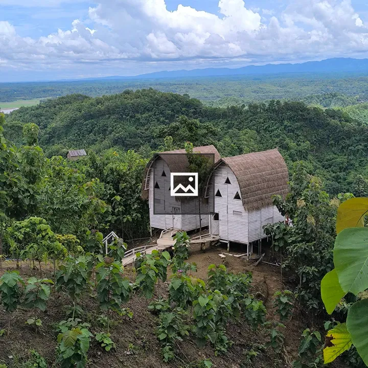 Two wooden cabins on hillside