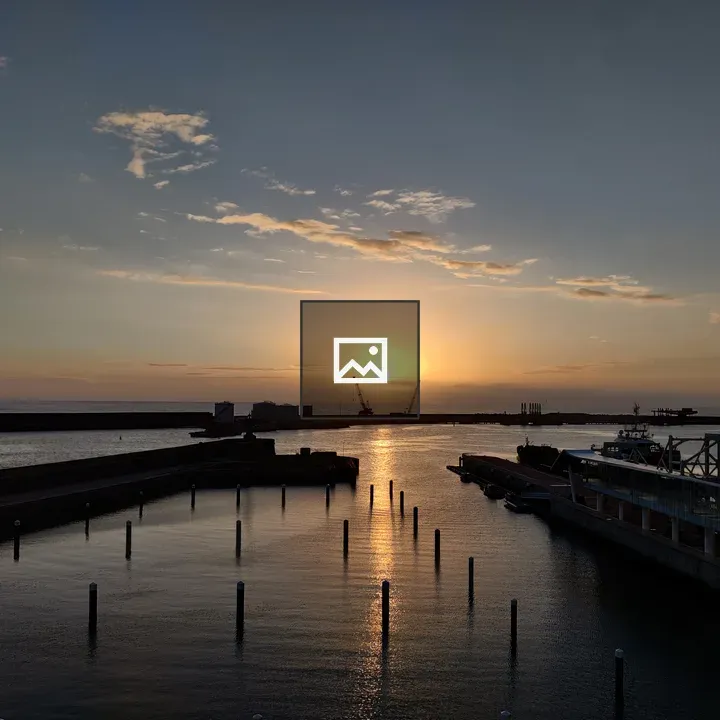 Sunset over harbor with dock and boat