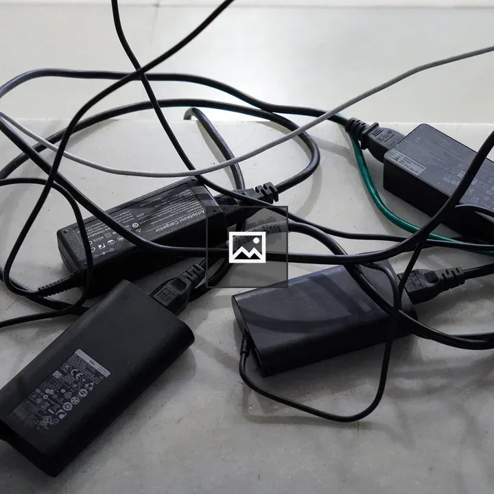 Black power adapters and tangled cables