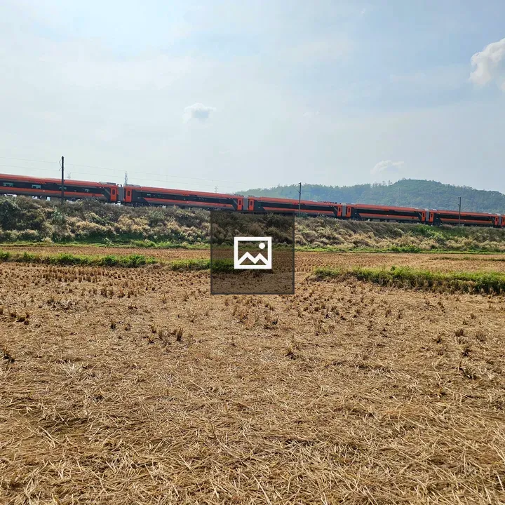 Orange Intercity Train over Rural Fields