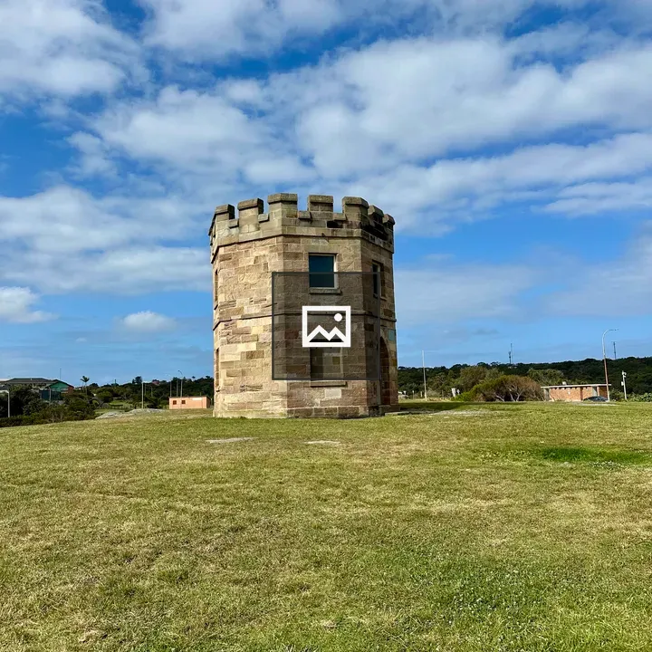 Circular stone tower on grassy field