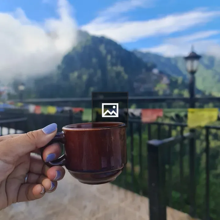 Tea cup in hand with mountains