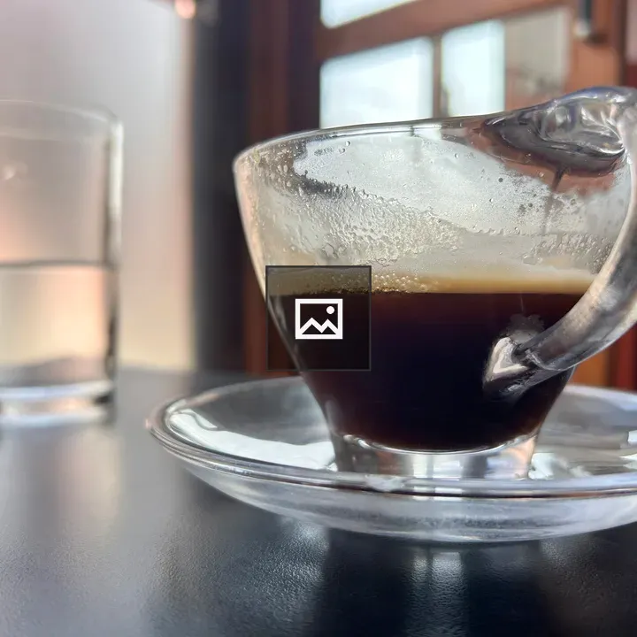 Coffee in foreground with glass of water