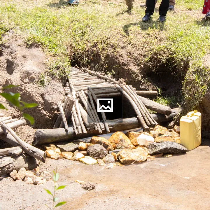 Stream with wooden bridge and yellow container