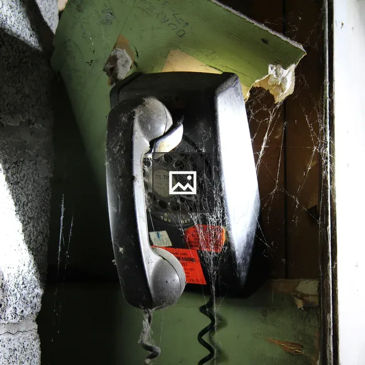 Broken rotary phone on wall