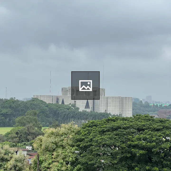 Grey geometric building towering above trees
