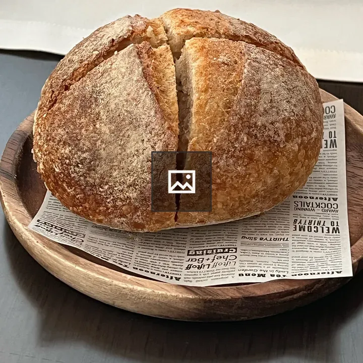 Round loaf with cross-cut on wooden plate