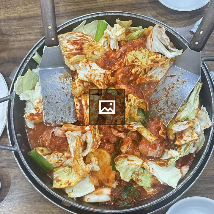 A round metal pan with vegetable curry