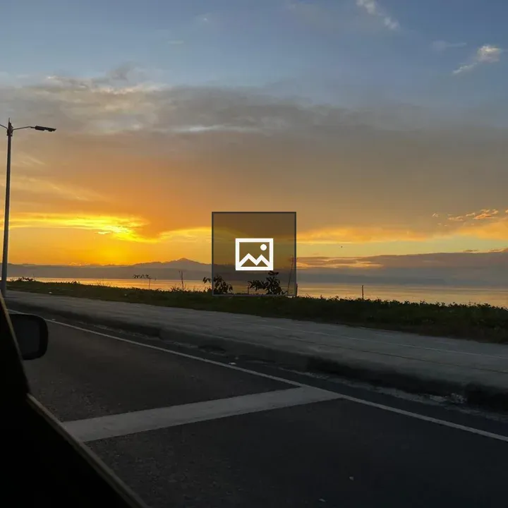 Sunset Over Ocean with Road and Mountains