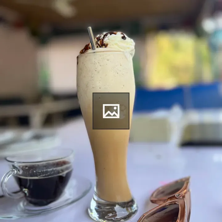Tall iced coffee on table