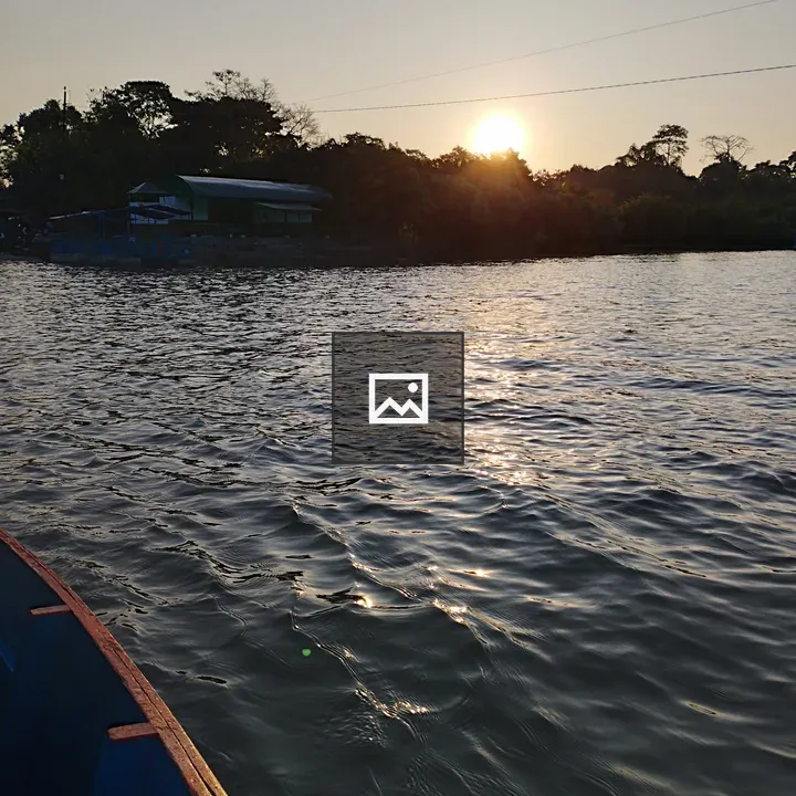 Sunset over lake with boat and horizon