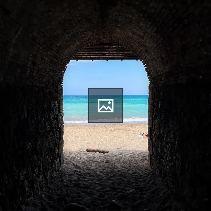 Beach view through a dark tunnel