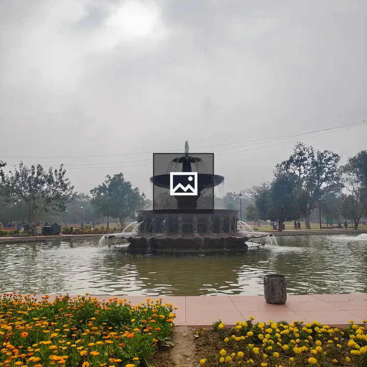 Decorative fountain in pond with marigolds