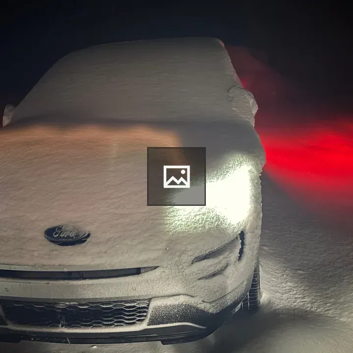Snowy car with lights on