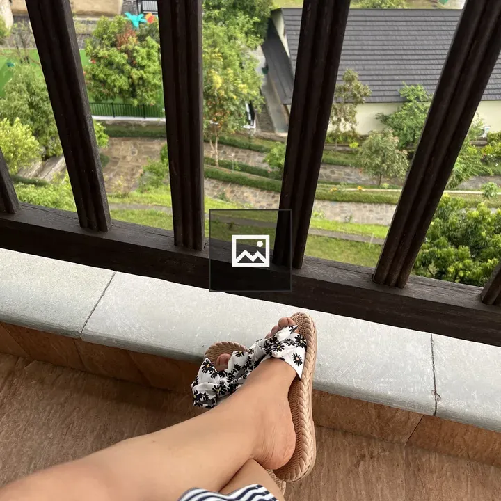 Crossed legs on balcony with striped dress
