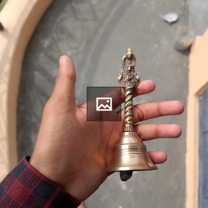 Hand Holding Brass Bell
