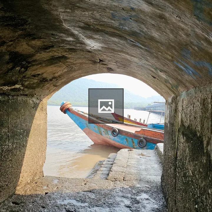 Old wooden boat through stone arch