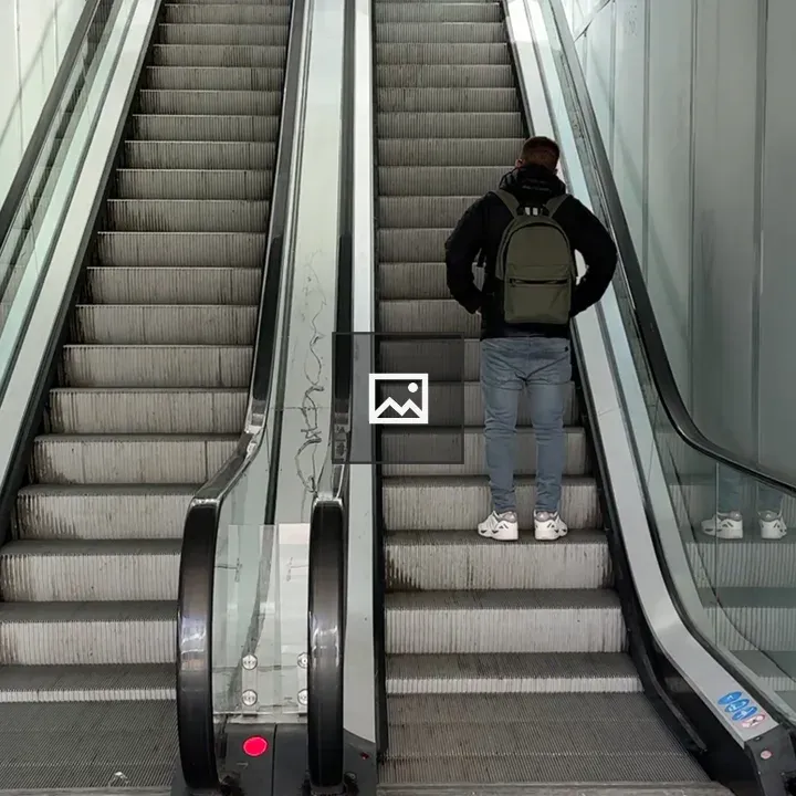 Man on an escalator in urban setting