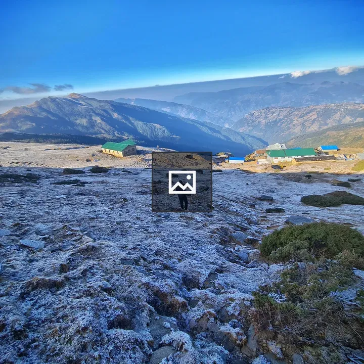 Person Walking on Snowy Mountain Slope