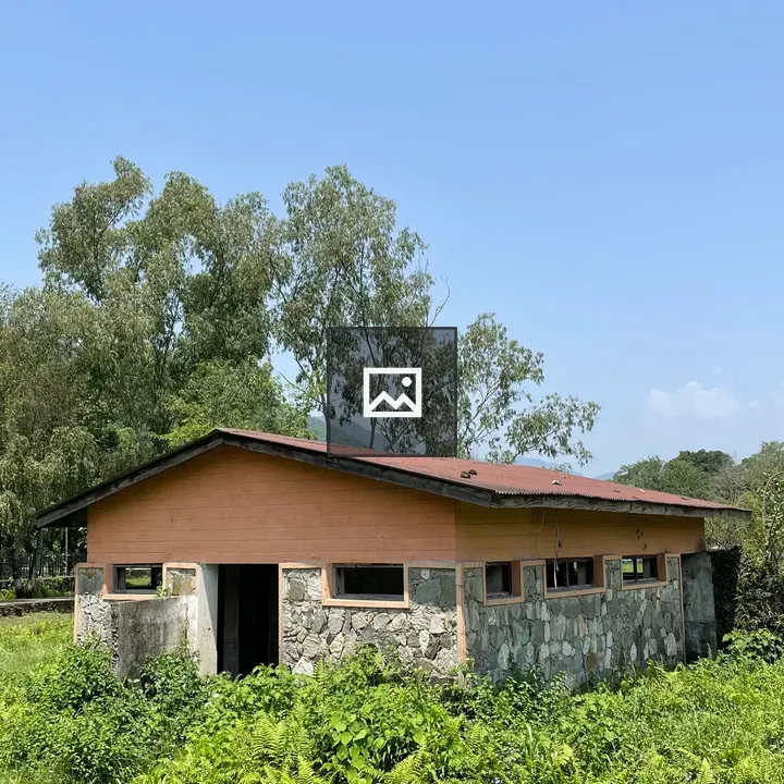 Small roofed building in rural field