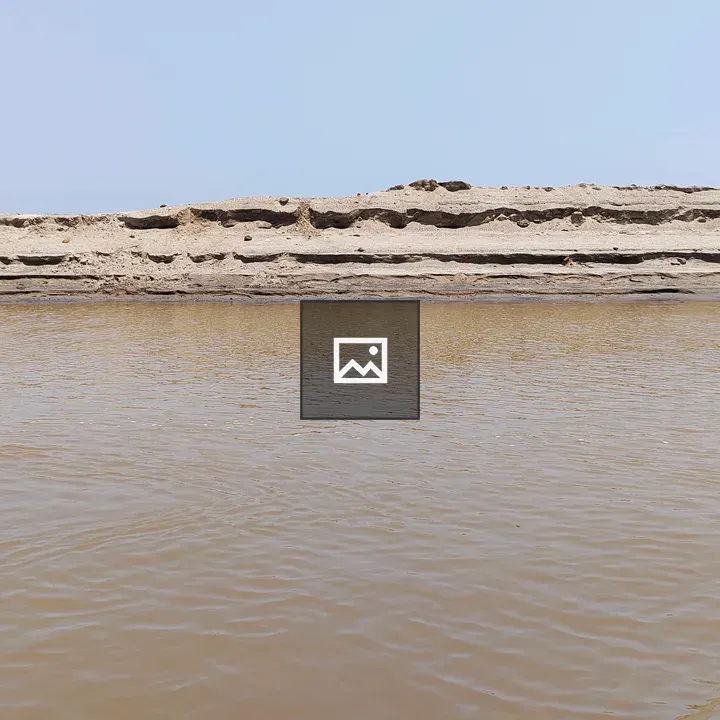 River view over muddy water to sandy bank