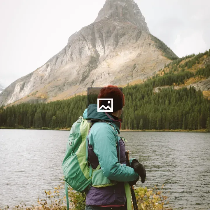 Person in winter gear by lake and mountain