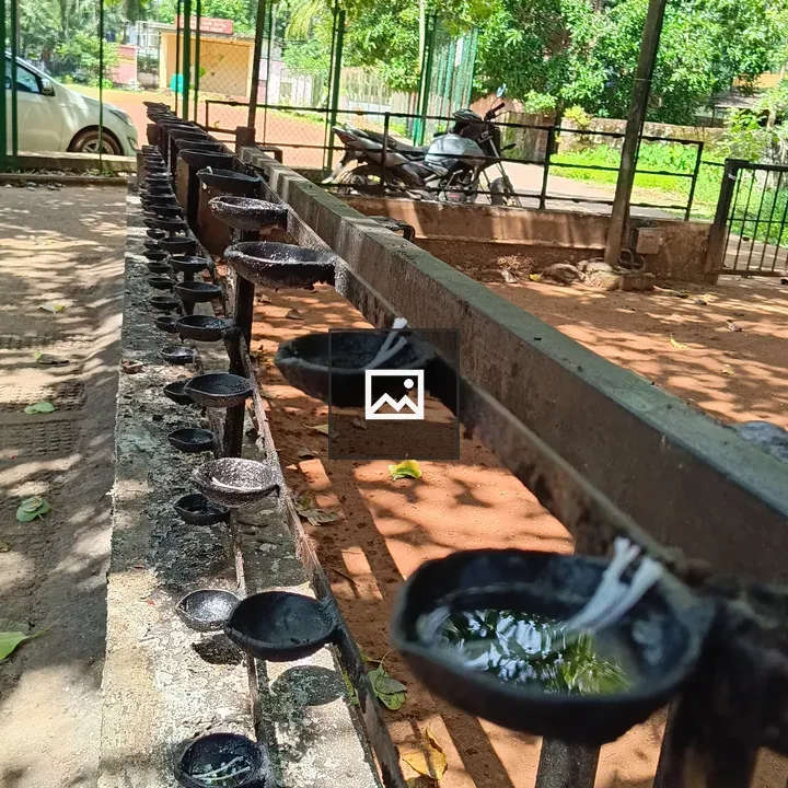Black oil lamps in front of temple