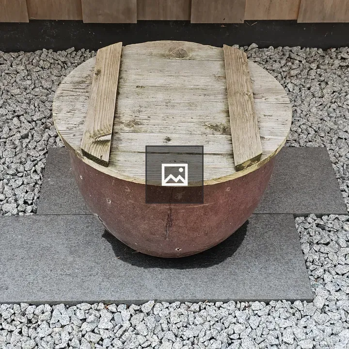 Half-buried pot with wooden lid