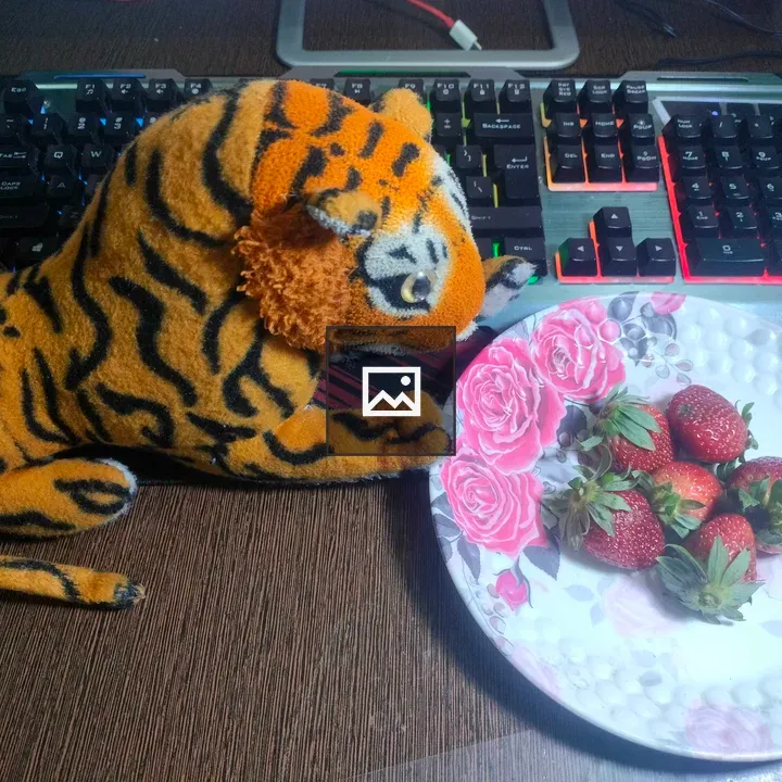 Toy tiger by keyboard and strawberries