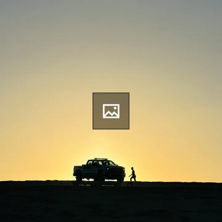 Man Walking Toward Truck at Sunset