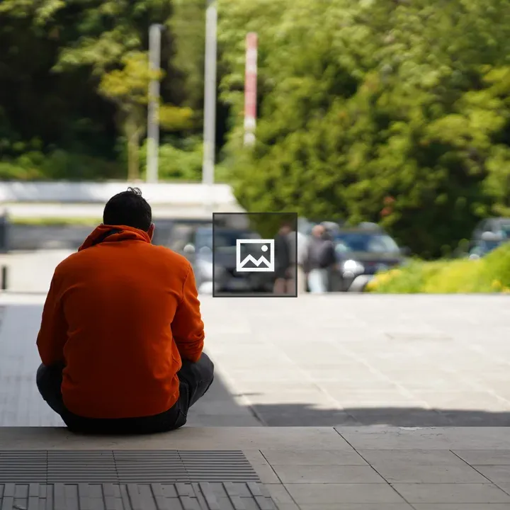 Person in Orange Hoodie Sitting
