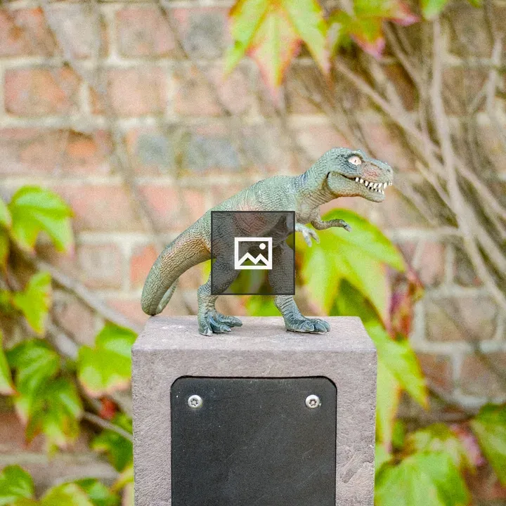 Plastic Dinosaur on Stone Post