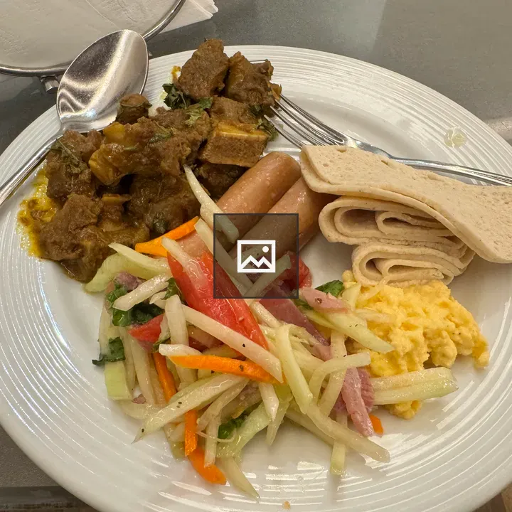 Plate of food with curry and sausages