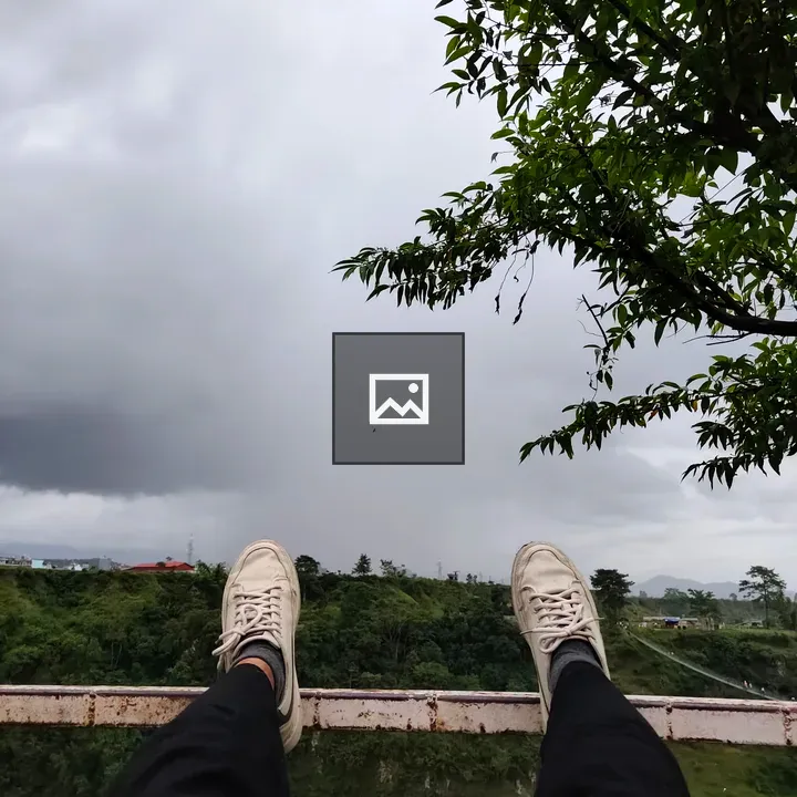 Feet in Sneakers Over Green Landscape