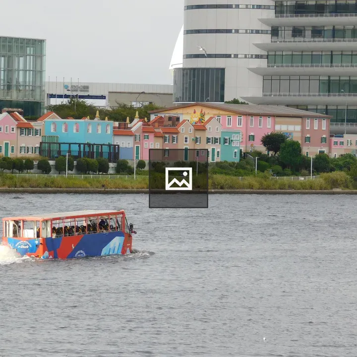 Water bus on river with pastel buildings