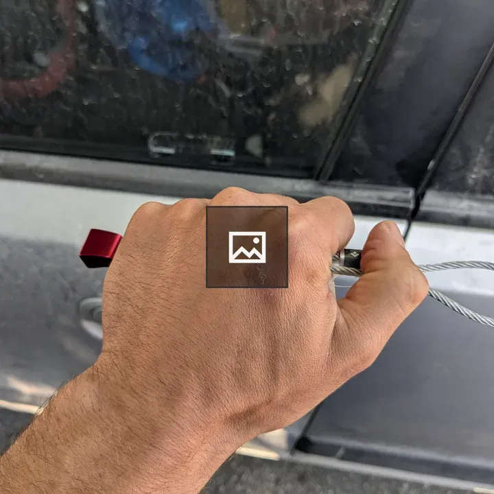 Hand Gripping Red Tool by Car Door
