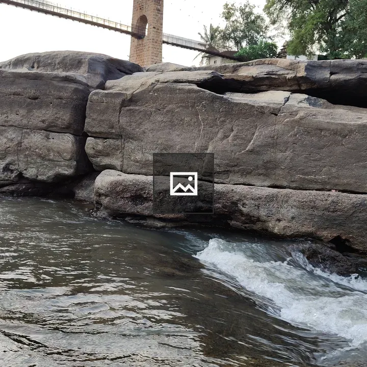 Flowing water at Gokak Falls with hanging bridge