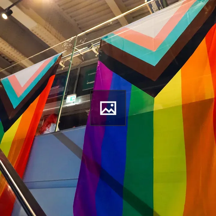 Progress Pride flags on glass balcony