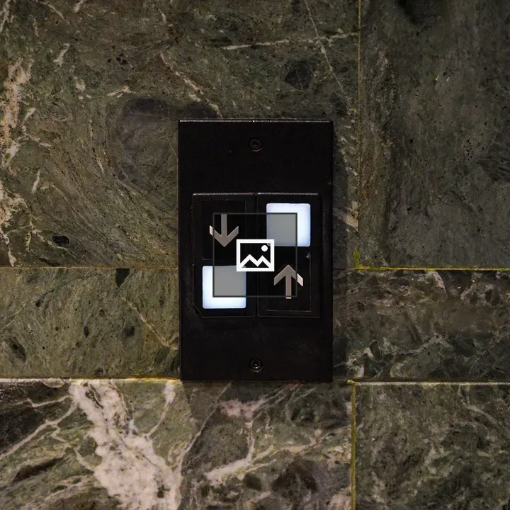 Confusing elevator controls on green marble