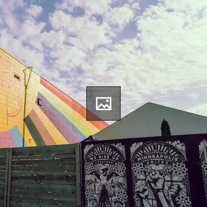 Rainbow mural on yellow brick wall