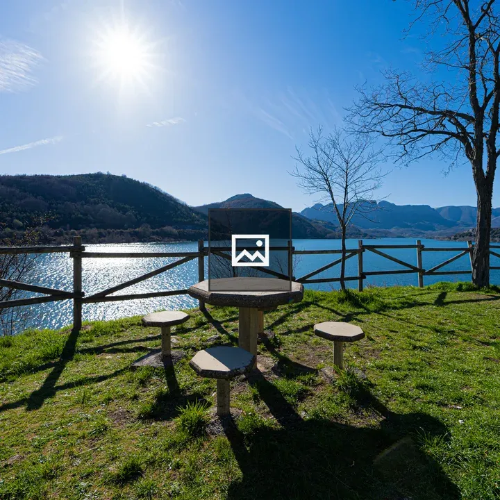 Table with wooden benches by blue lake