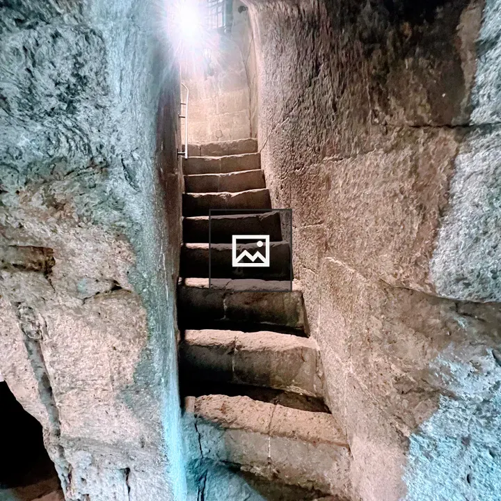 Steep stone staircase under archway