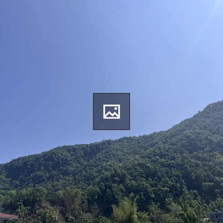 Clear blue sky over green mountain landscape